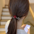 A sleek phone line hair ring with a glossy red gemstone and polished silver spheres for graceful red love style