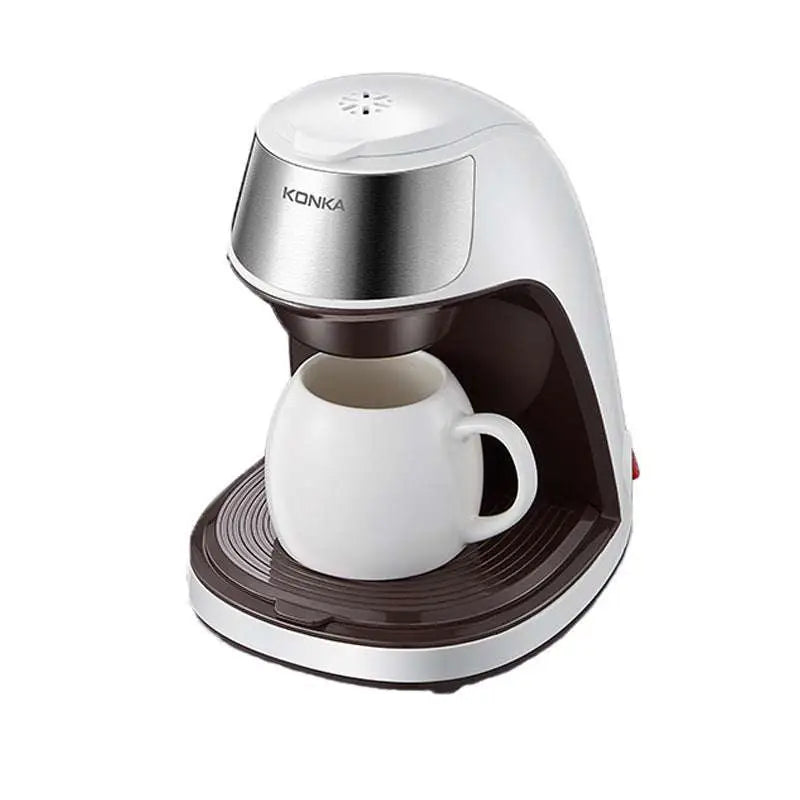 Silver and brown konka fully automatic single serve portable coffee machine with stainless steel body and white ceramic mug beneath spout