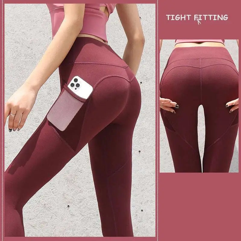 Maroon high-waisted gym sport seamless leggings with side pocket holding a smartphone for active use