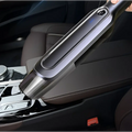 A sleek gray and black cordless handheld vacuum cleaner with metallic finish and blue led indicator light