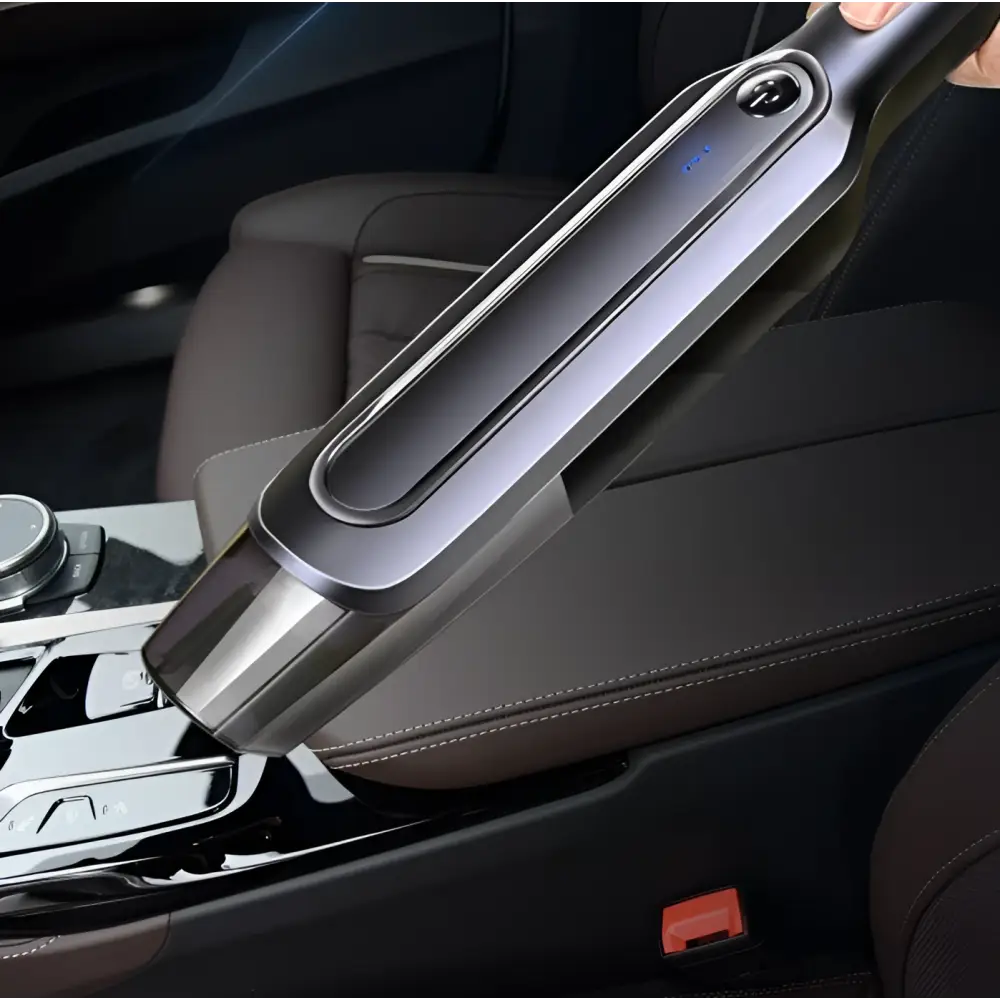 A sleek gray and black cordless handheld vacuum cleaner with metallic finish and blue led indicator light