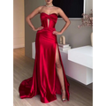 A striking red satin strapless evening dress with a high slit and front cutout detail long satin strapless gown