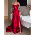 A striking red satin strapless evening dress with a fitted bodice and high slit long satin strapless design