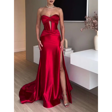A striking red satin strapless evening dress with a fitted bodice and high slit long satin strapless design