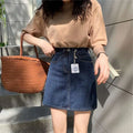 A small denim skirt in summer dark blue with a high-waisted straight cut and visible stitching details