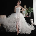 A white small trailing wedding dress with a fitted bodice and a layered tulle skirt for elegant occasions