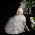 A flowing white small trailing wedding dress with a strapless bodice and layered tulle skirt for elegant occasions