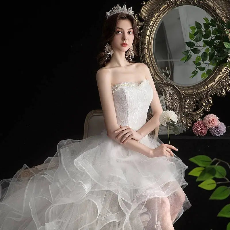 A white small trailing wedding dress with a fitted bodice and a layered tulle skirt for elegant occasions