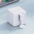 White cube-shaped wireless charging pad with circular power button and magnetic dock for bluetooth finger robot voice control applications