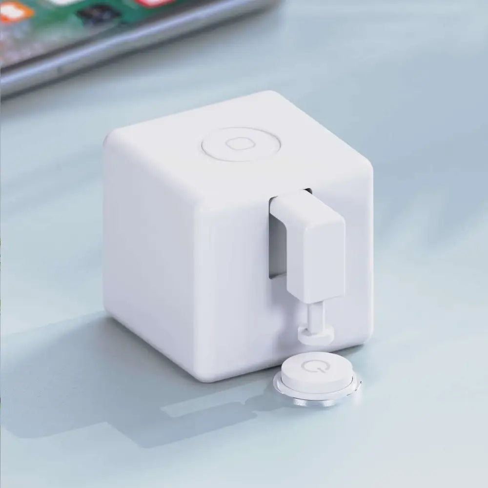 White cube-shaped wireless charging pad with circular power button and magnetic dock for bluetooth finger robot voice control applications