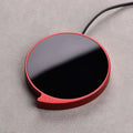 Red circular smart coffee mug warmer with glossy black center metallic red frame and three temperature settings