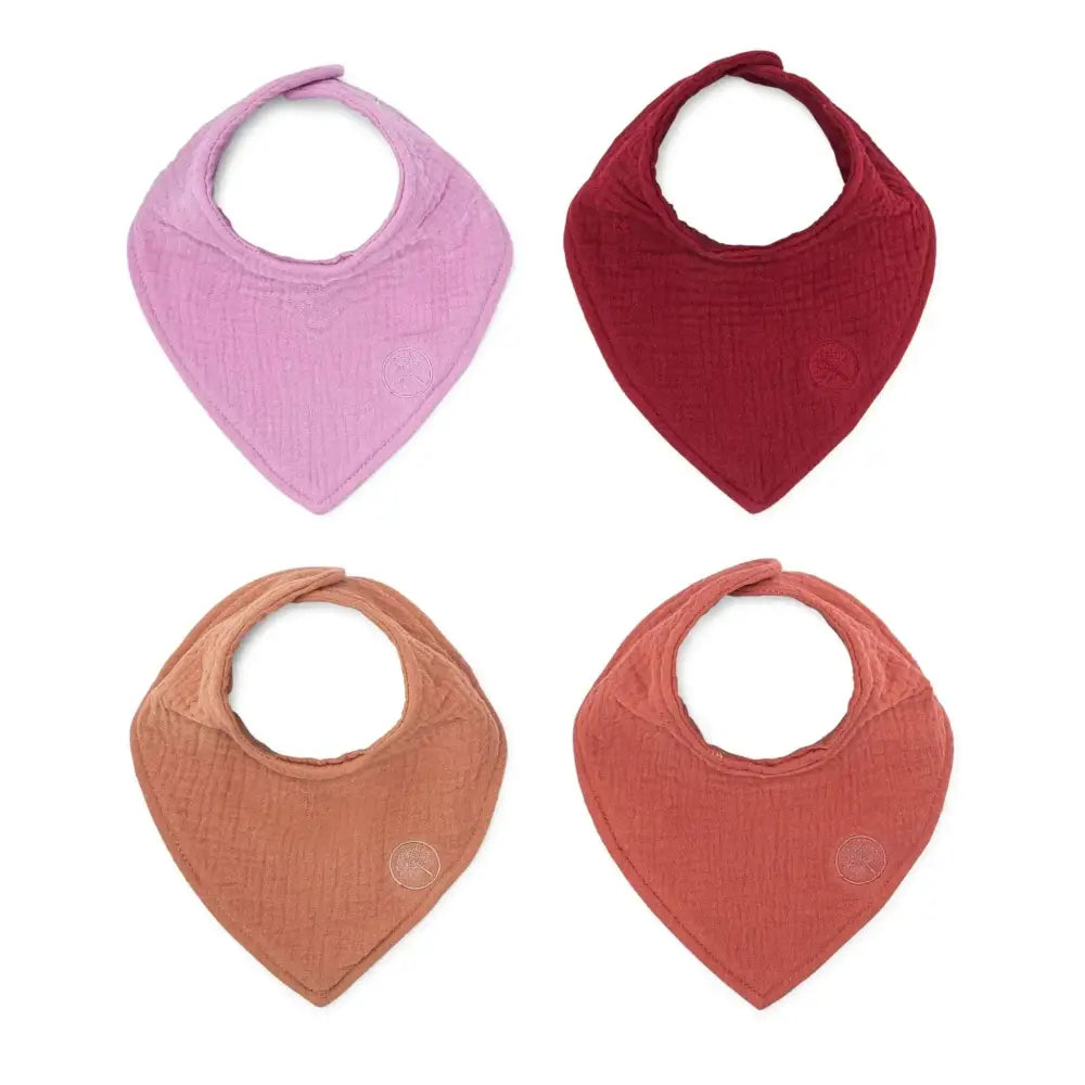 Set of four soft muslin cotton bandana bibs in pastel pink, deep red, warm terracotta, and muted orange colors