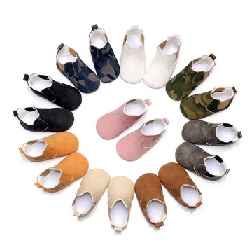 A collection of soft suede baby toddler booties in solid colors and camouflage patterns for infants and toddlers
