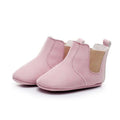 Soft pink soft suede baby toddler booties with tan elastic side panels and white stitching suede baby shoes