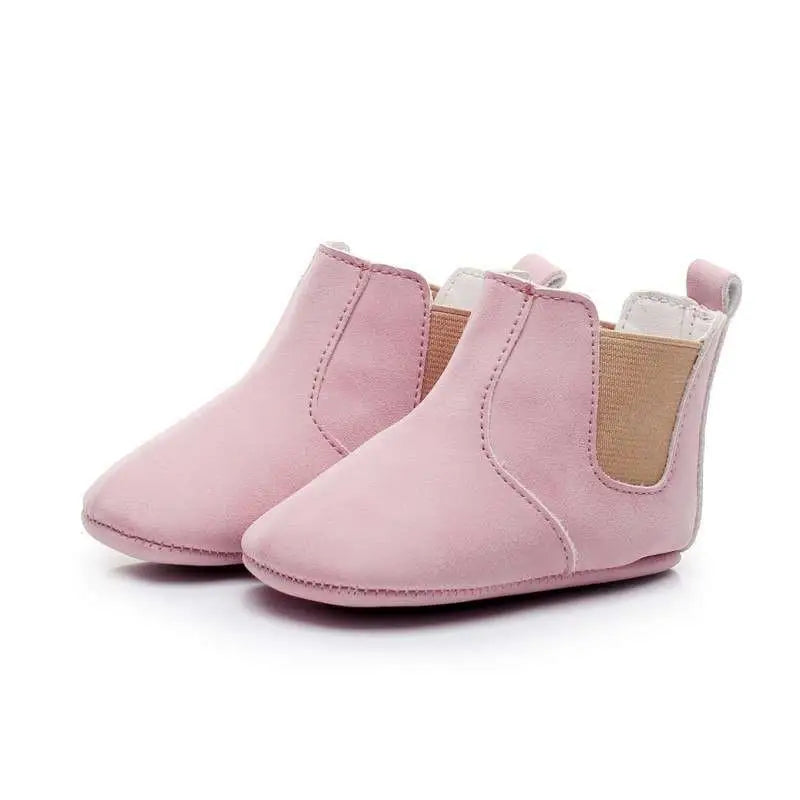 Soft pink soft suede baby toddler booties with tan elastic side panels and white stitching suede baby shoes