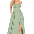 A flowing sage green satin evening gown with a fitted bodice, thin straps, and a high slit along the leg