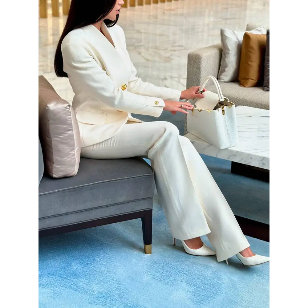 White leather handbag with gold-tone hardware paired with a solid color single-breasted blazer and pants set