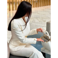 White leather handbag with gold-tone hardware and top handles paired with solid color single-breasted blazer and pants set