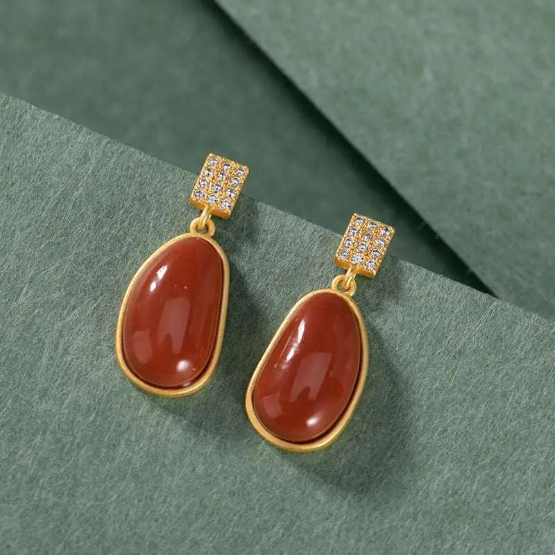 Elegant gold-toned drop earrings featuring southern red agate teardrop stones with square pave diamond accents
