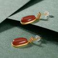Elegant southern red agate lucky bean drop earrings with oval reddish-brown stones set in gold-toned metal and diamond accents