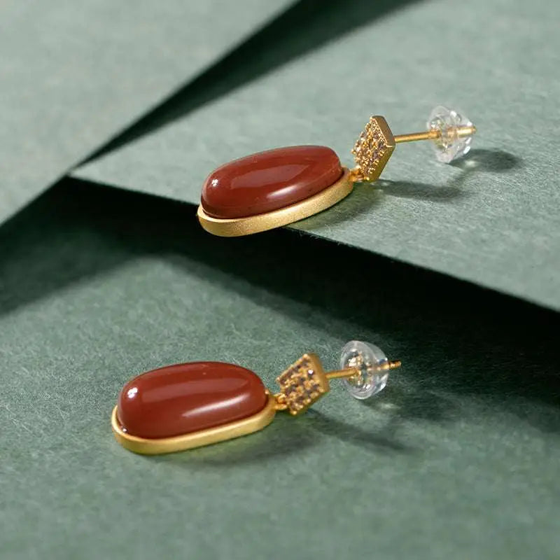 Elegant southern red agate lucky bean drop earrings with oval reddish-brown stones set in gold-toned metal and diamond accents