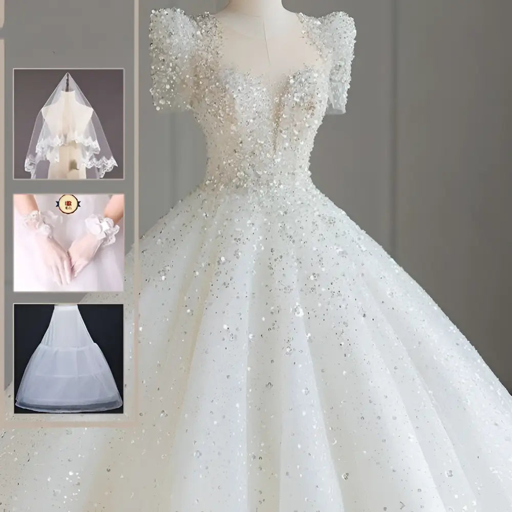 A sparkling beaded white wedding dress with intricate beading off-the-shoulder sleeves and a voluminous white trailing wedding tail