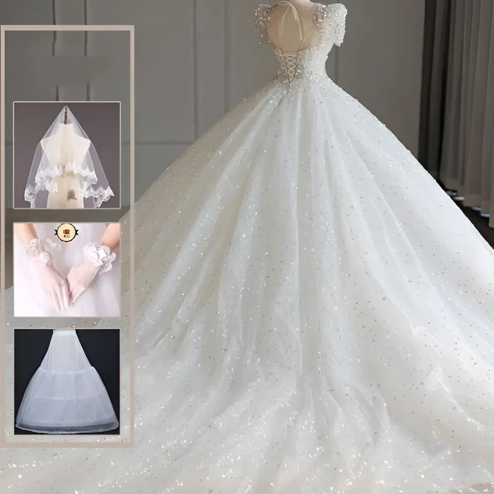 A sparkling beaded white wedding dress with a fitted bodice, off-the-shoulder sleeves, and a voluminous trailing skirt