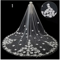 A delicate white lace bridal wedding dress veil featuring intricate floral appliqués along its hem and length