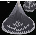 A delicate white bridal wedding dress veil with intricate floral embroidery and flowing sheer fabric for weddings