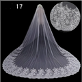A delicate white lace bridal wedding dress veil with intricate floral patterns and flowing sheer mesh design