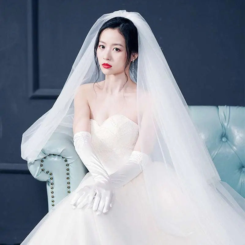 A flowing white sparkling wide style bridal wedding dress veil with intricate floral lace and soft sheer texture