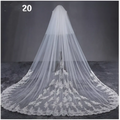 A delicate white lace bridal wedding dress veil with intricate floral embroidery and a sheer flowing design