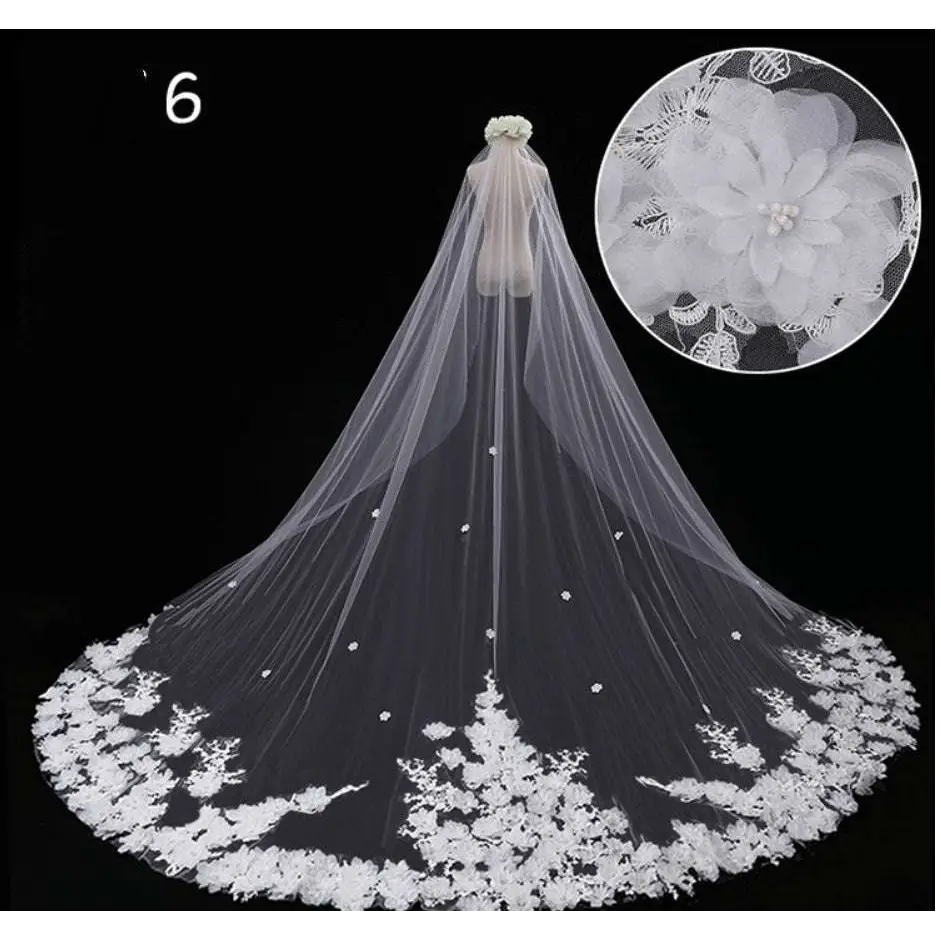 A delicate white lace wedding dress veil with intricate floral embroidery and pearl embellishments along the edge