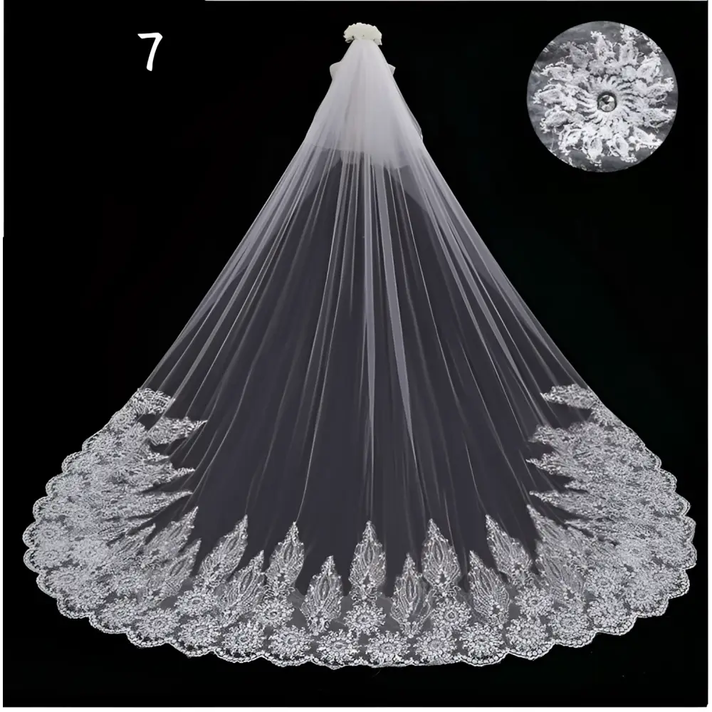 A delicate white lace wedding dress veil with intricate floral embroidery and a small bouquet at the top