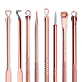 Set of rose gold-toned steel beauty needle tools with textured grips and various tips in a zippered case for acne extraction