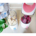 Pink and white steel electric lemon juicer with transparent container filled with diced dragon fruit for efficient lemon juicing