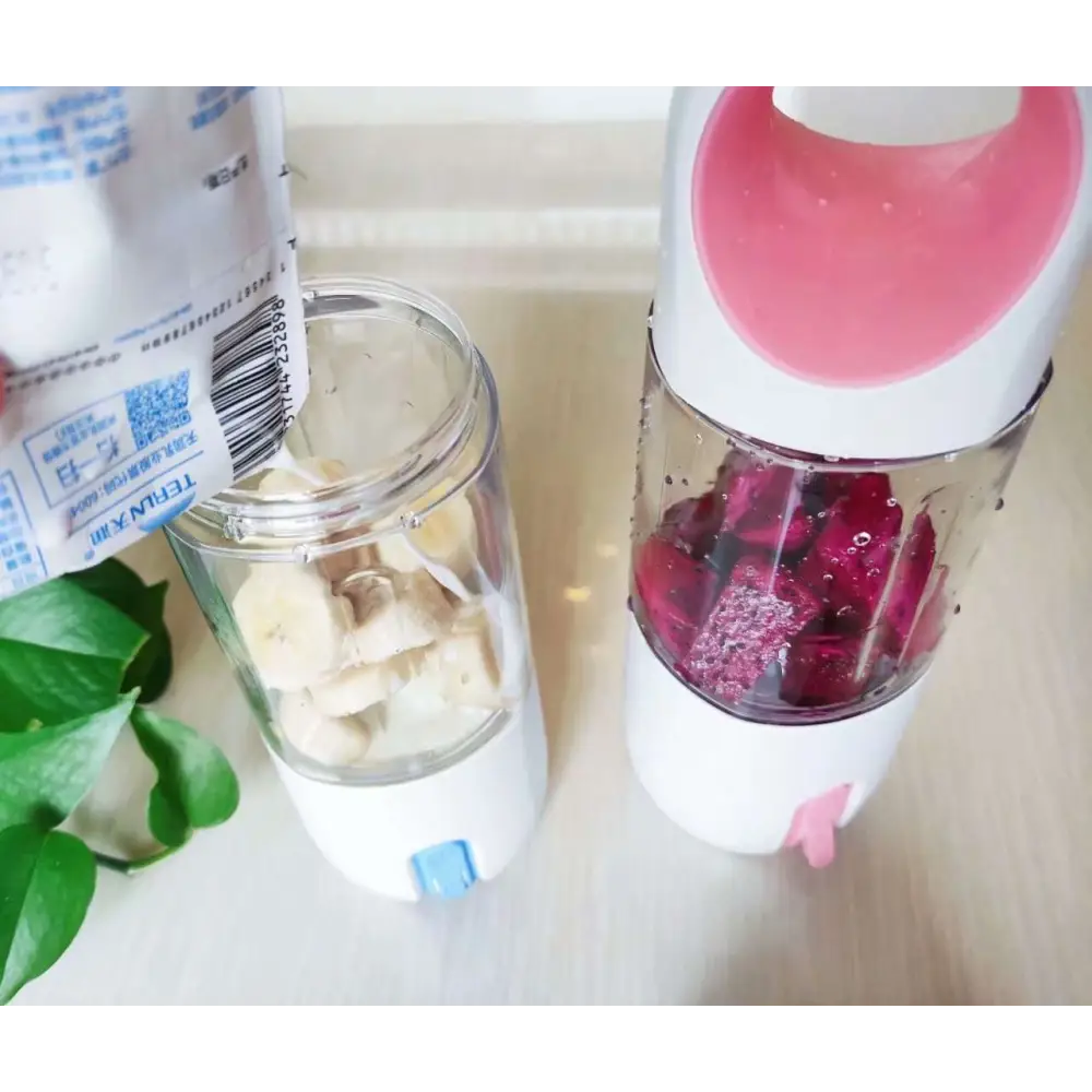 Pink and white steel electric lemon juicer with transparent container filled with diced dragon fruit for efficient lemon juicing