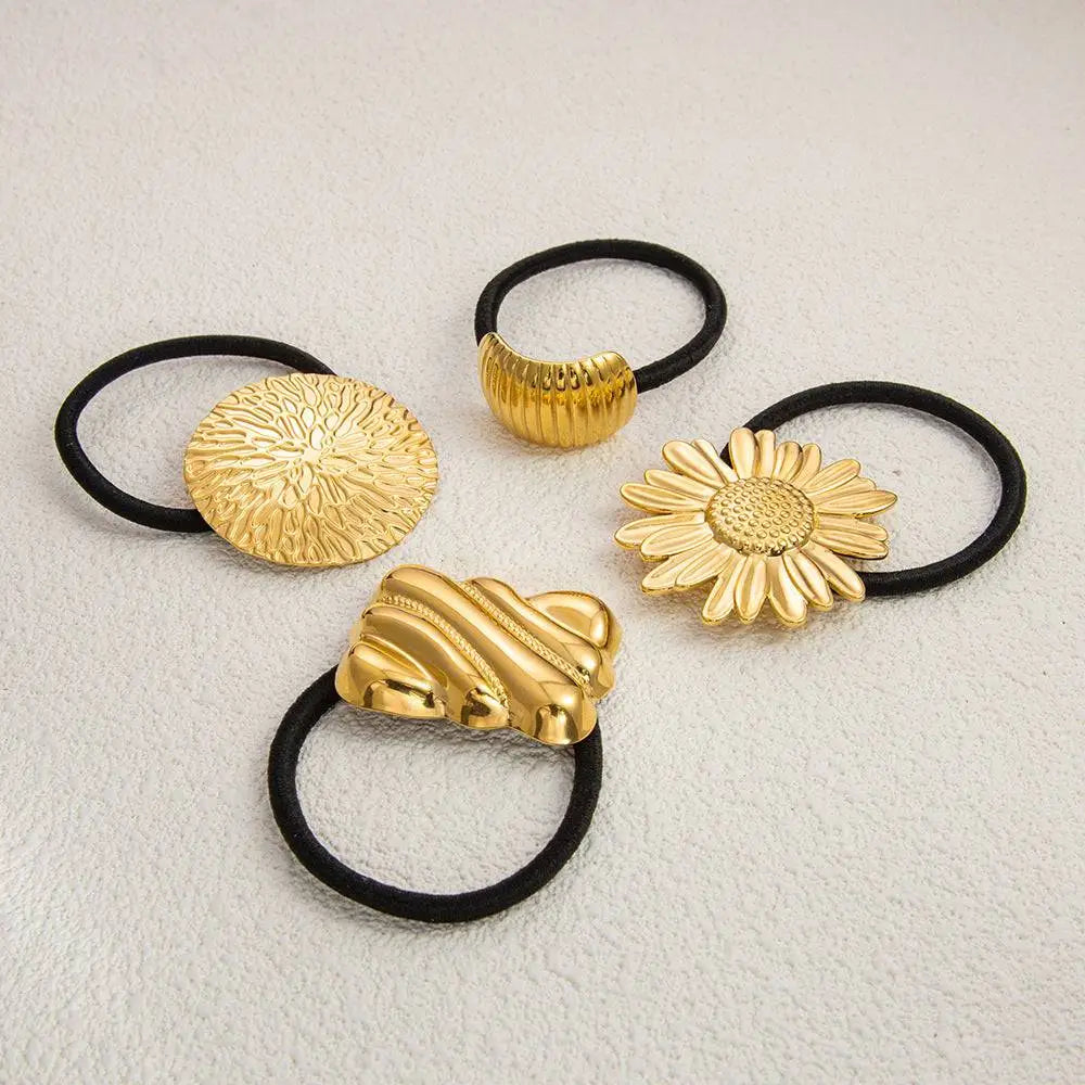 Gold-toned stainless steel flower elastic hair ties with black bands featuring floral and shell-like designs