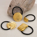 Gold-toned stainless steel flower elastic hair ties with intricate floral and abstract designs on black bands