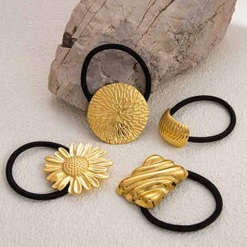 Gold-toned stainless steel flower elastic hair ties with intricate floral and abstract designs on black bands