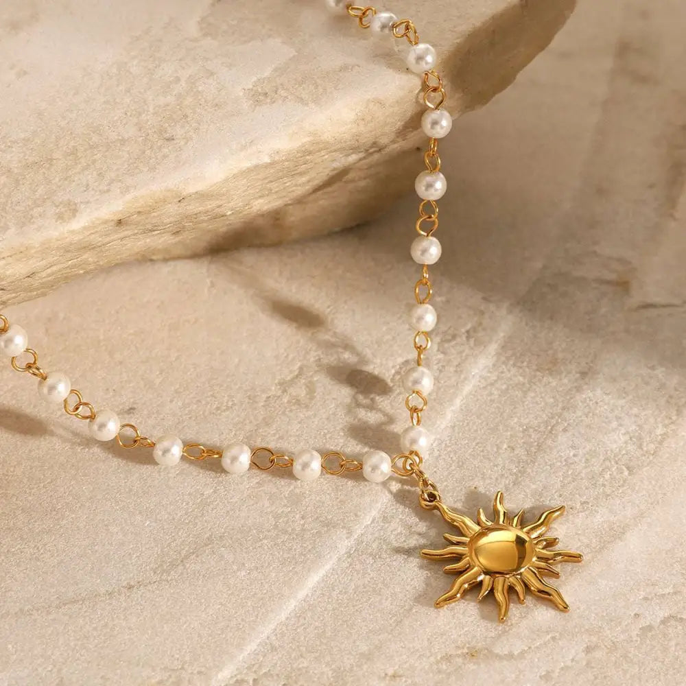 Stainless steel pearl necklace featuring a gold sun pendant with small white pearls on a delicate chain