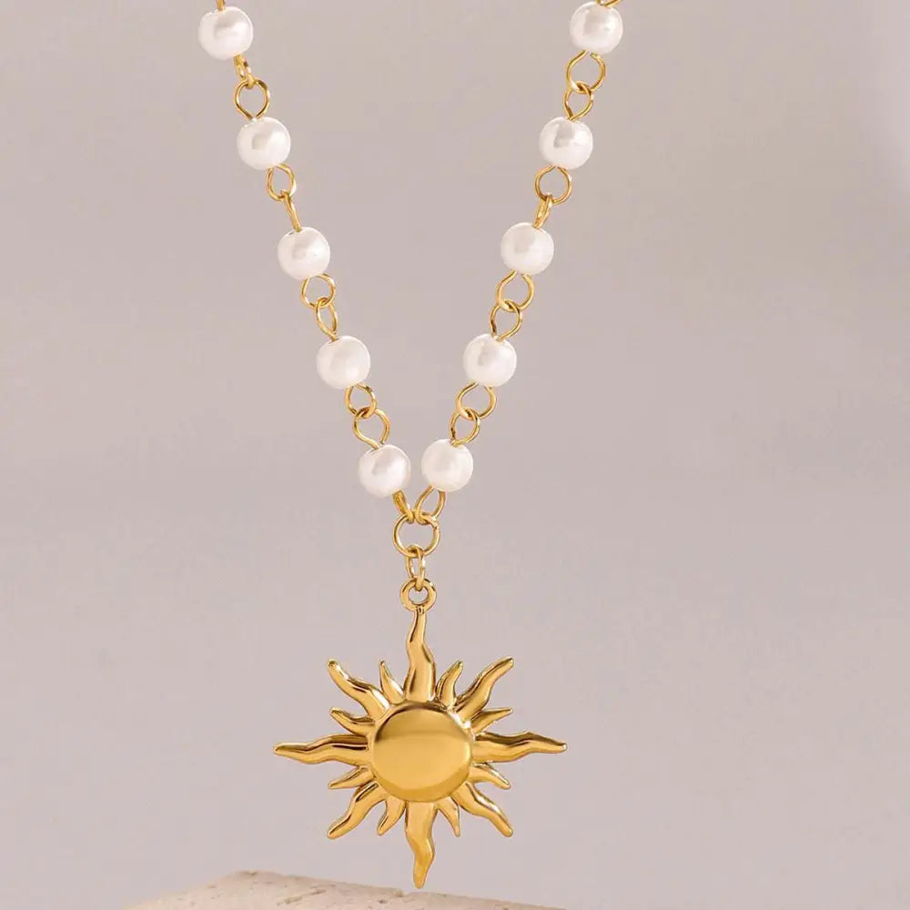 Stainless steel pearl necklace featuring a gold sun pendant with a chain of alternating small white pearls and gold links