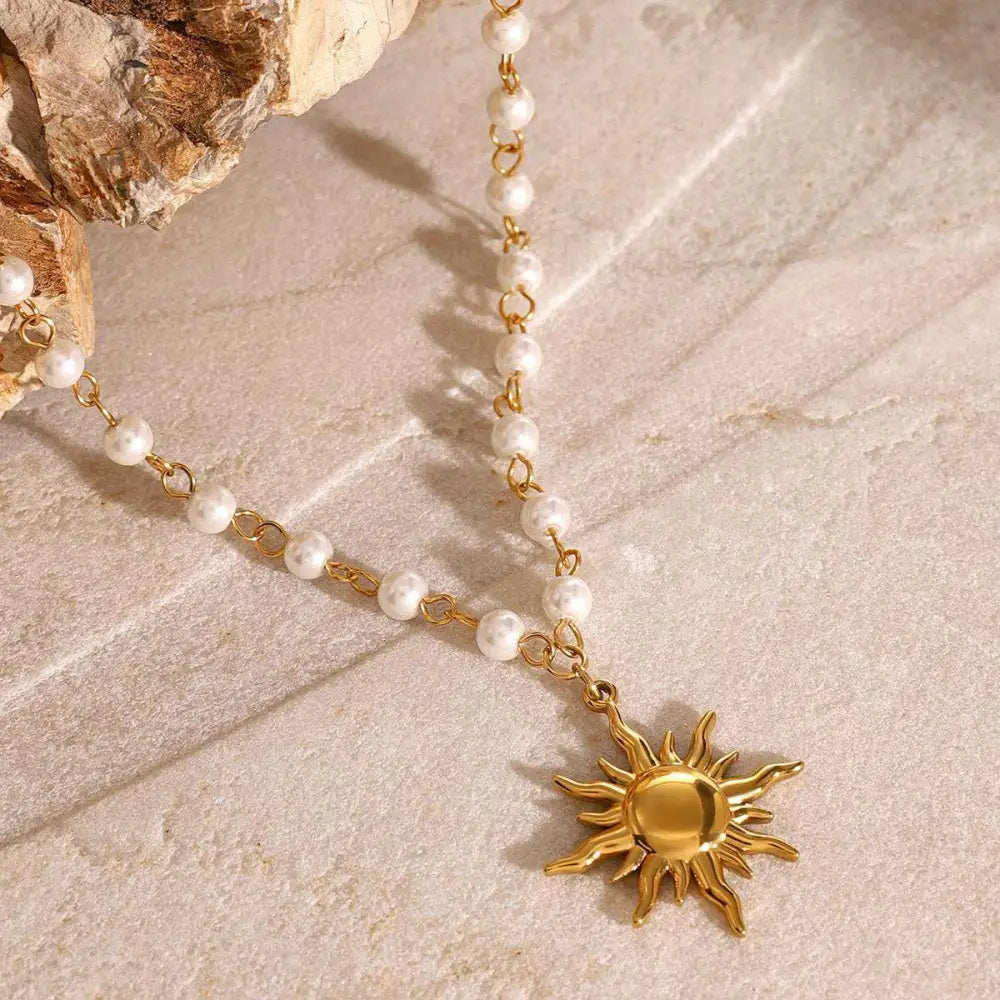 Stainless steel pearl necklace with gold sun pendant featuring small white pearls and intricate golden links
