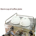 Two white ceramic espresso cups rest upside down on a stainless steel semi-automatic espresso machine rack with polished chrome finish and pressure gauge