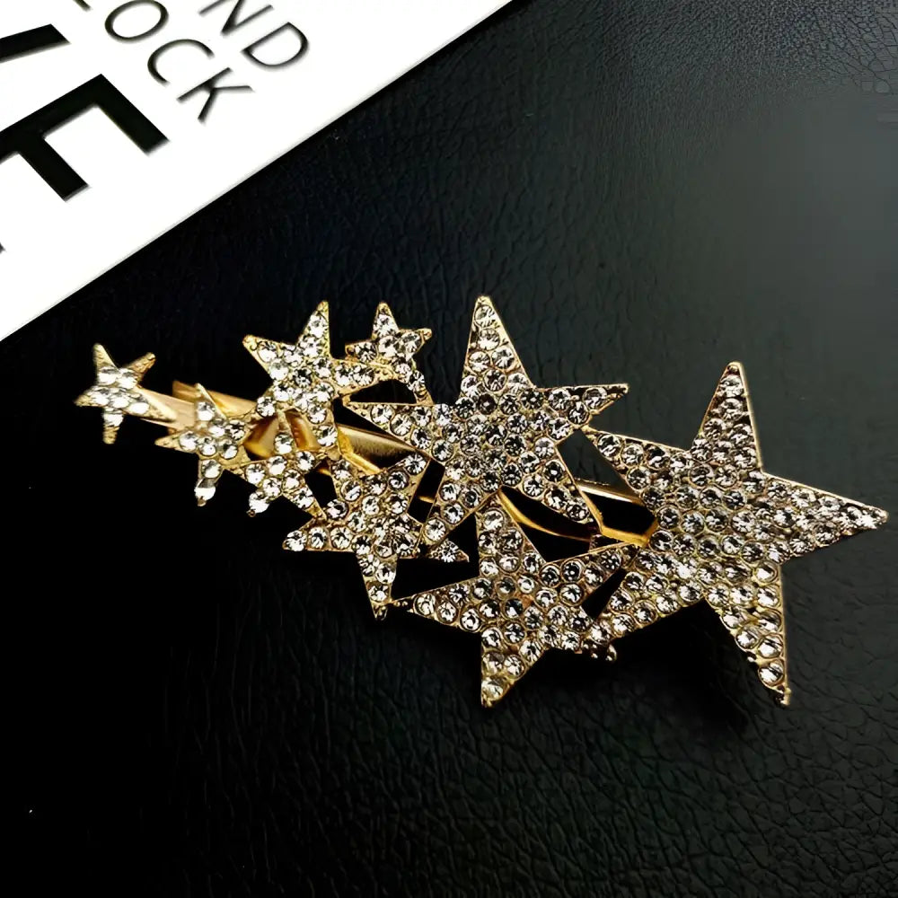 A sparkling gold star diamond barrettes adorned with numerous clear rhinestones featuring small pentagrams head styling