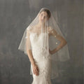 A delicate sheer white lace bridal veil with floral embroidery and subtle star-shaped embellishments in variable mso-font-signature design