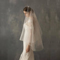 A delicate white lace bridal veil with floral embroidery and tiny star-shaped embellishments in variable mso-font-signature design