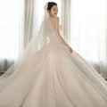 Strapless ivory wedding gown with fitted bodice and expansive layered skirt in luxury women’s fashion