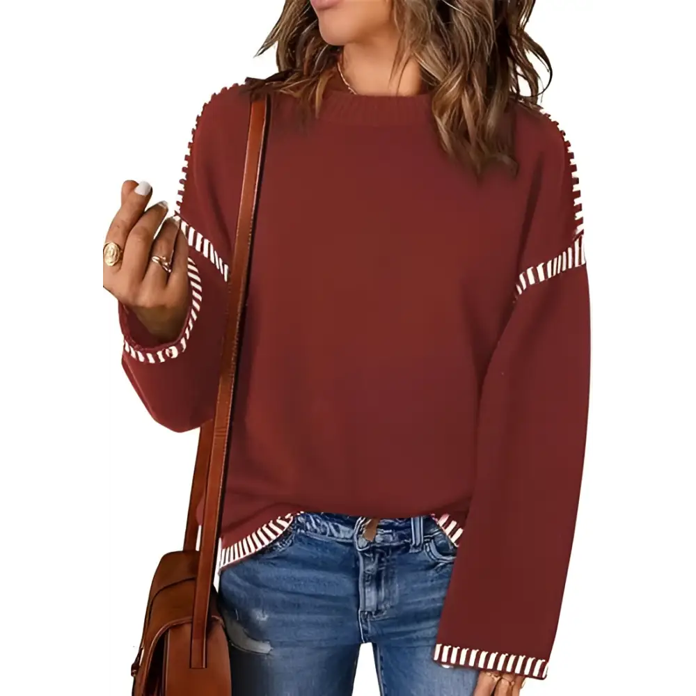 A cozy maroon round neck pullover knit sweater with white striped accents on sleeves and hem
