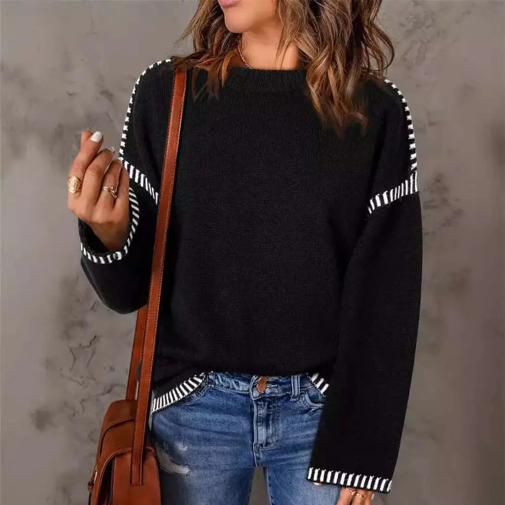 Black round neck pullover knit sweater with white striped accents on sleeves and hem for casual wear